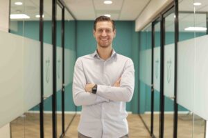 Man met armen over elkaar in kantoorruimte - Marketingrecruiters
