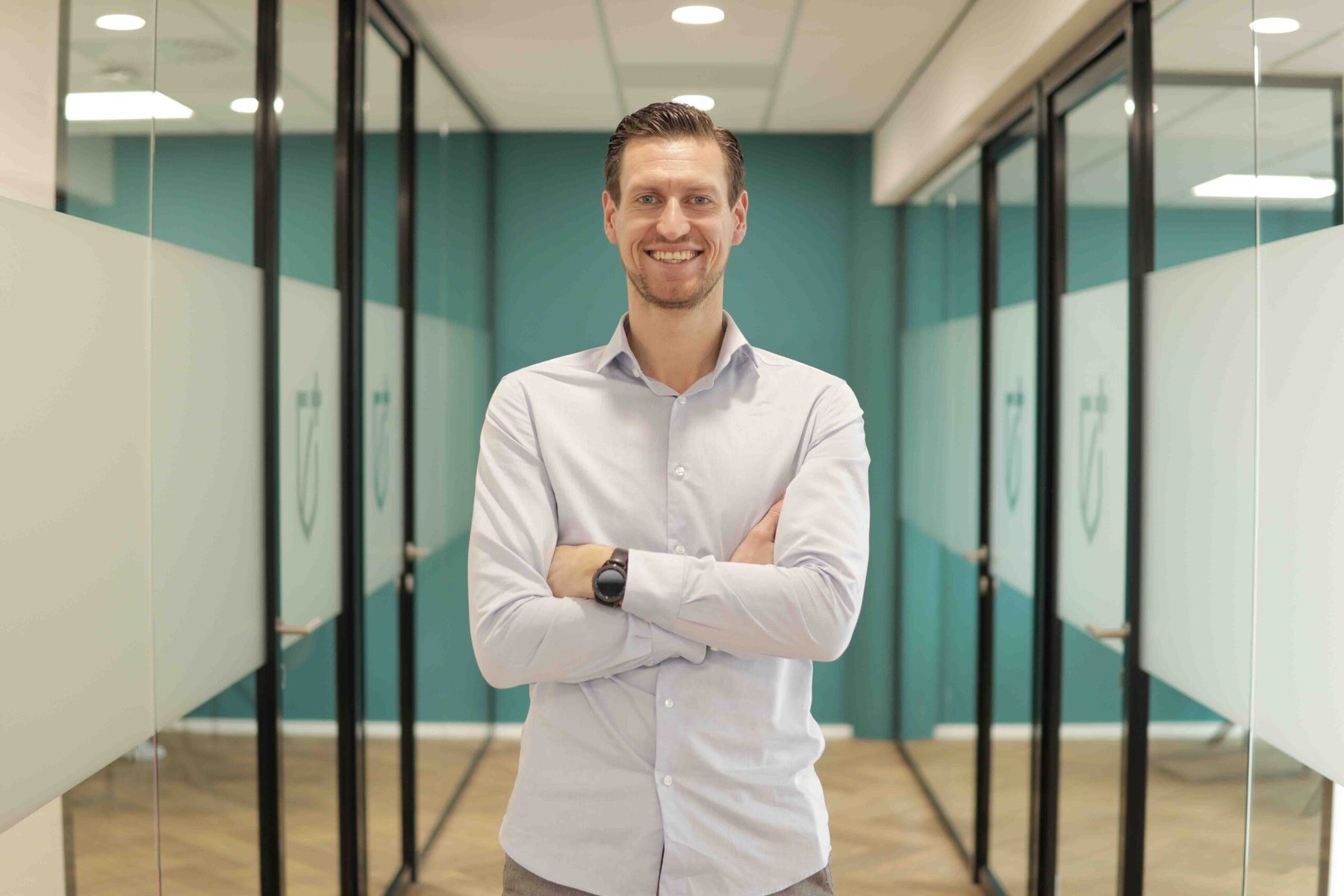 Man met armen over elkaar in kantoorruimte - Marketingrecruiters